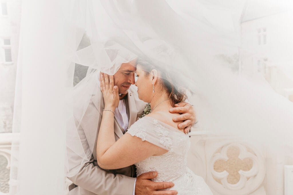 mariés sous un voile avec le photographe de mariage