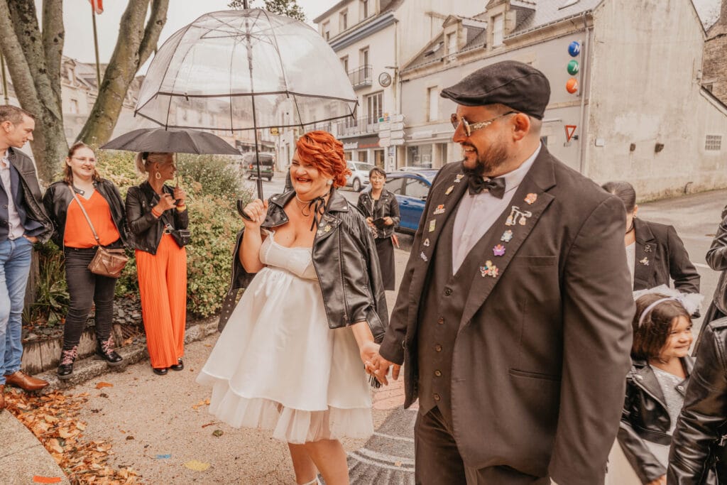 mariés sortant de la marie sous la pluie avec leu photographe de mariage à rennes