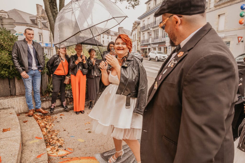 mariés sortant de la marie sous la pluie avec leu photographe de mariage à rennes