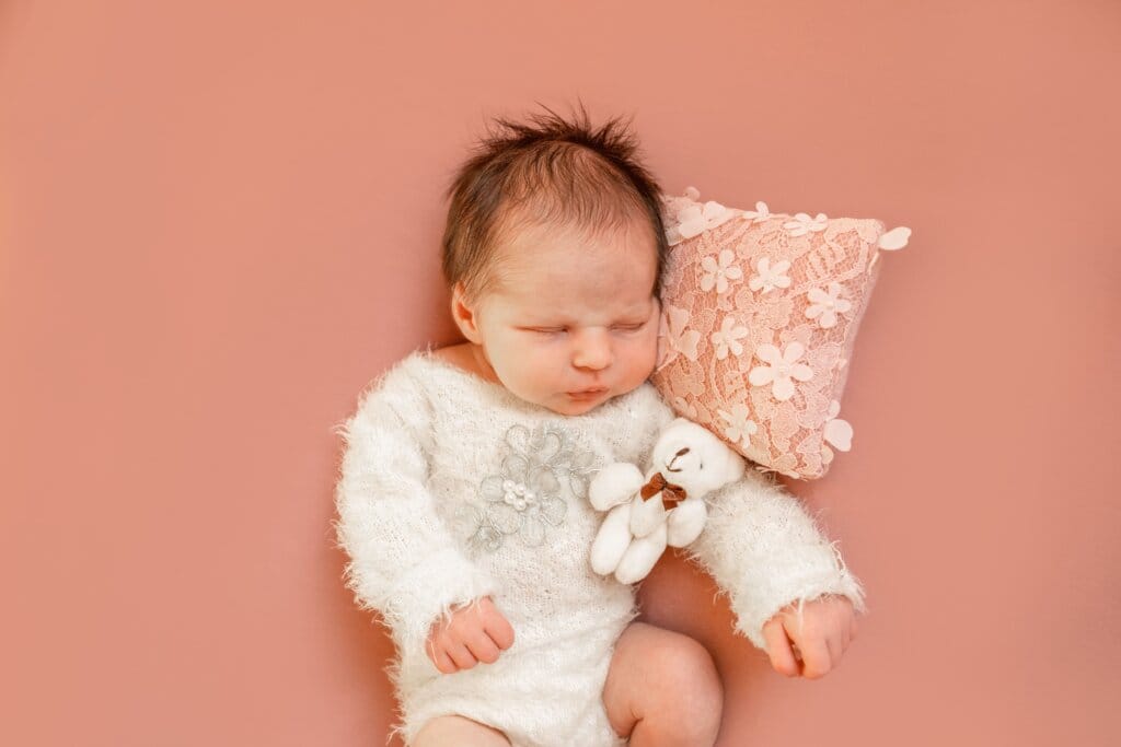 Séance photo naissance à Rennes avec un bébé endormi, réalisée dans un style épuré et chaleureux.