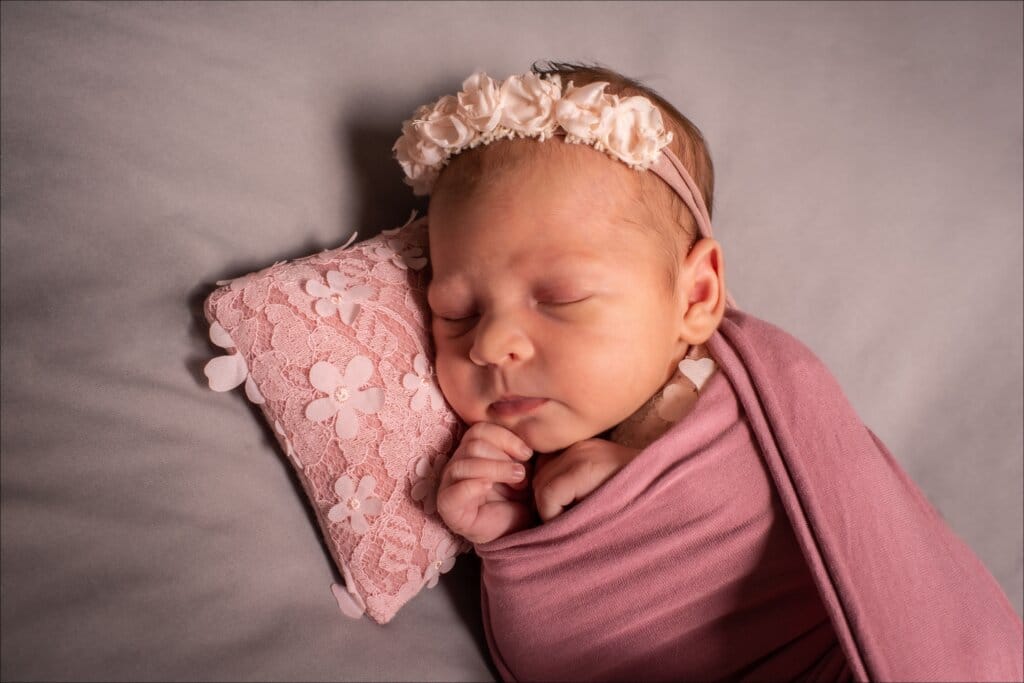 Bébé nouveau-né emmailloté photographié en studio à Rennes dans une ambiance douce et apaisante.