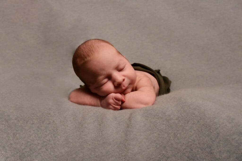 Bébé nouveau-né emmailloté photographié en studio à Rennes dans une ambiance douce et apaisante.
