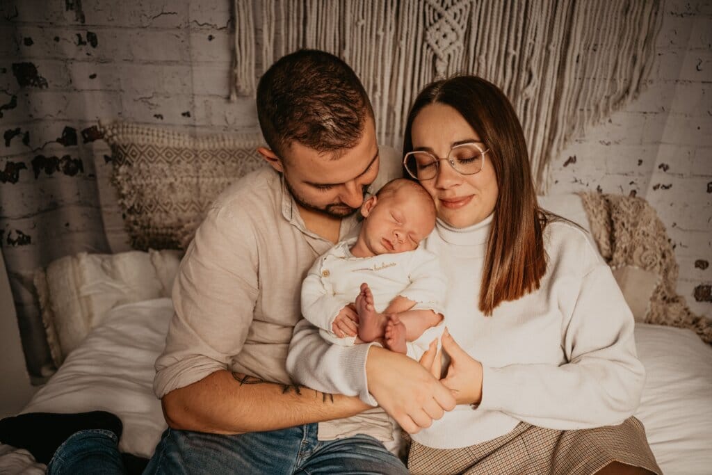 Parents tenant leur bébé nouveau-né lors d’une séance photo naissance à Rennes, moment de tendresse et de complicité.