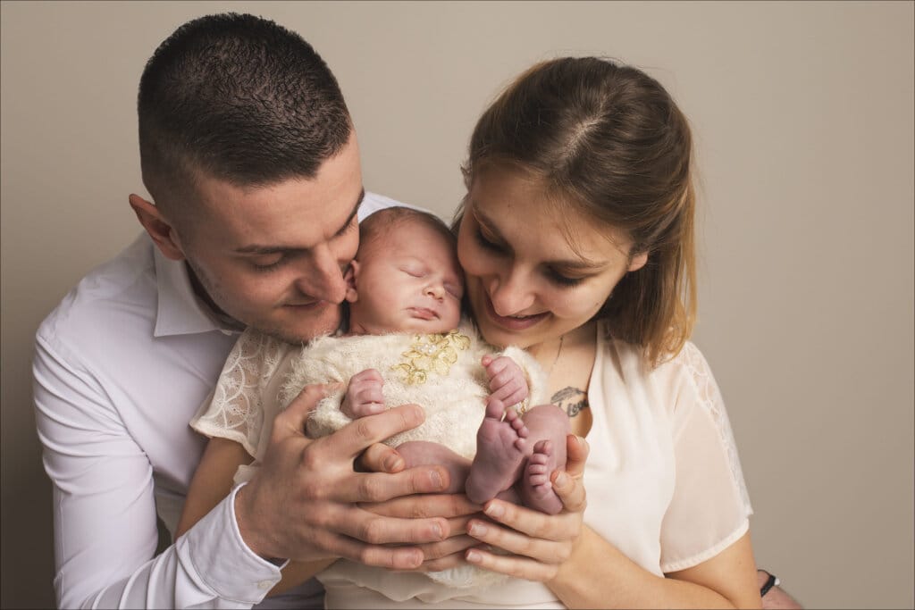 Regard tendre d’un père vers son bébé nouveau-né pendant une séance photo naissance à Rennes.